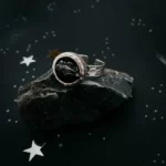 Amazing Round Raw Meteorite Ring in Silver standing on a meteorite rock