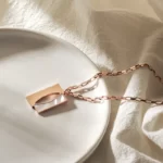 the Square Shell Necklace on a white plate