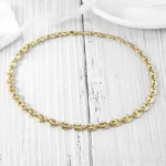 the Adorable Coffee Bean Chain Necklace on a wooden surface