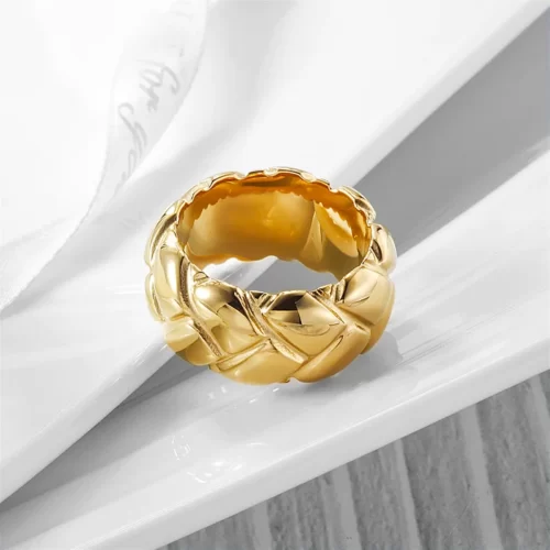 the Bold Golden Braided Ring on a white-marbled surface