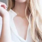 a blonde hair woman in a white top is wearing the Dainty Golden Cubic Zirconia Pendant Necklace