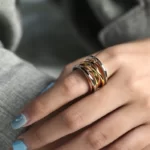 close up photo of the hand of a woman wearing the Ecstatic Tricolor Intertwined Statement Ring