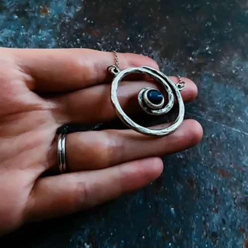 a hand holding the Marvelous Handmade Spiral Silver Necklace