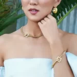 a woman in a white top wearing the Square Toggle Clasp Golden Chain Necklace