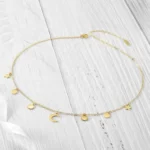 the Stunning Golden Celestial Necklace on a white wooden surface