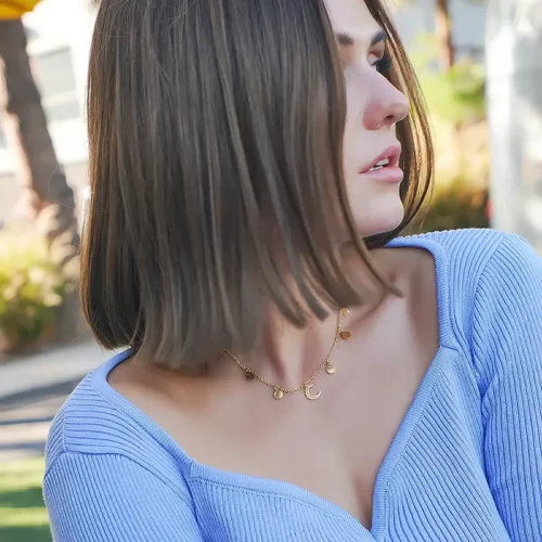 a woman in a blue top wearing the Stunning Golden Celestial Necklace on her neck