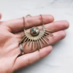 the Unique Handmade Sun Pendant With Turquoise on a hand