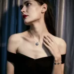 a woman in a black dress wearing the Sterling Silver Round Evil Eye Necklace