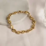 the Breathtaking Golden Coffee Bean Chain Bracelet on a marble piece