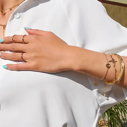 a woman in a white dress wearing the Exciting Golden Heartbeat Bracelet