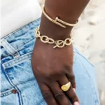 a woman wearing the Gold Screw Nail Bangle And Wire Link Bracelet Set