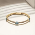 a close up photo of the turquoise stones of the New Gold Cable Bangle With 3 Turquoise Stations