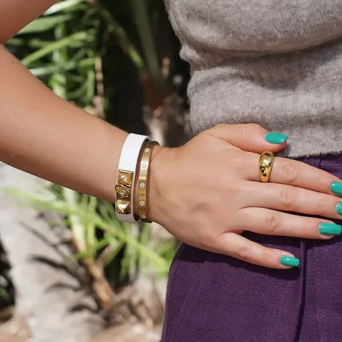 a woman wearing the Gold Plated Leather Bangle Set With CZ on her arm