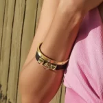 a woman in a pink dress wearing the Gold Plated Leather Bangle Set With CZ