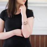 a woman in a black dress wearing the Astonishing Moon Phase Stacked Bangle Set on her arm