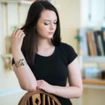 a woman wearing the Astonishing Moon Phase Stacked Bangle Set on her arm