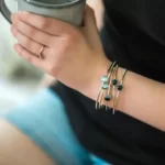 a woman holding a cup of coffee is wearing the Astonishing Moon Phase Stacked Bangle Set