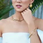 a woman in a white dress wearing the Mind-Blowing Golden Toggle Clasp Bracelet on her arm