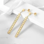 close up photo of the gold-toned Pyramid Bar Earrings on a white surface