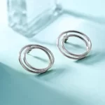 the Double Layered Silver Tone Hoop Earrings on a blue background