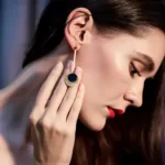 a woman wearing the Spectacular Gold Black Discs Dangle Earrings