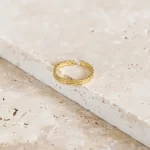 a simple and elegant wedding ring. Handmade Braided Wedding Ring Band For Women photo on a marble surface showing the beauty of the ring.